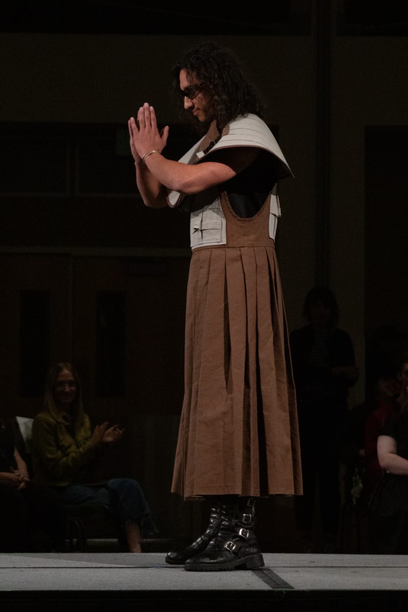 A model poses at the end of the runway, wearing a look designed by Ryan Baker, a senior in apparel design and production, as part of his collection The Sculpted Worker during Fashion Reframed, Colorado State University Design and Merchandising department’s annual student-run fashion show in the Lory Student Center ballrooms May 1. Baker won Best Collection, and was “inspired by the functional garments depended on every day, designed to protect, support, and last. The collection merges classic workwear with sculptural, avant-garde silhouettes, transforming traditional workwear.”