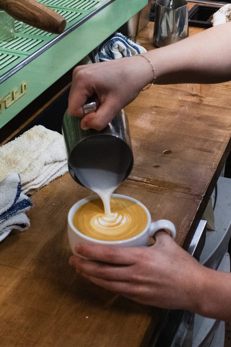 Anna Hickox, a barista at Trickster Bakery &amp; Cafe, pours steamed milk into a shot of espresso to make latte art at the cafe Aug. 20. Hickox was born and raised in Fort Collins, and has enjoyed working for the Cafe since it opened on August 10th. “It’s been so fun. It’s been a blast,” Hickox said.
