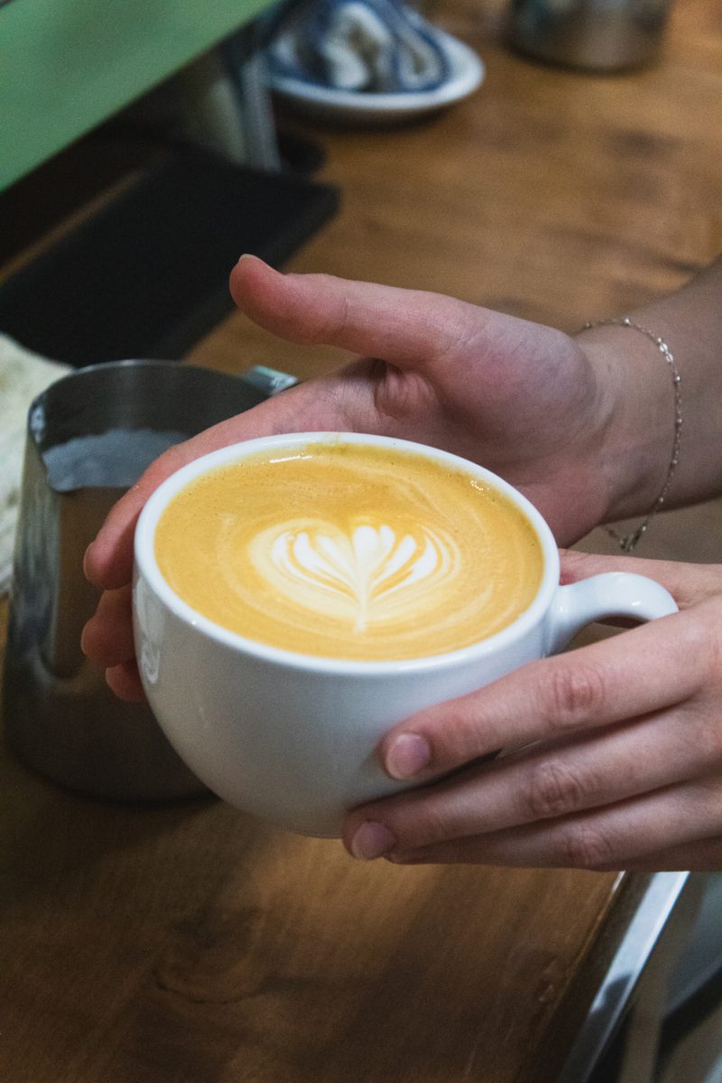 Anna Hickox, a barista at Trickster Bakery &amp; Cafe, holds a cup of coffee towards the camera after completing her latte art at the cafe Aug. 20. Hickox was born and raised in Fort Collins, and has enjoyed working for the Cafe since it opened on August 10th. “It’s been so fun. It’s been a blast,” Hickox said.