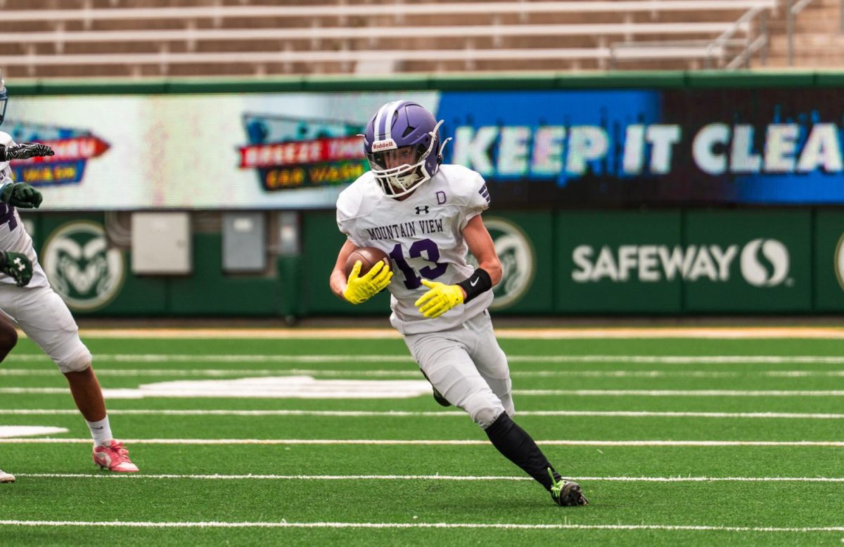 Mountain view running back Logan Miller (13) makes a run against Poudre defense.