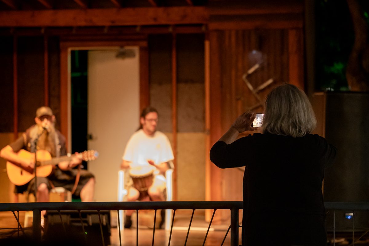 Mary Lu Lovett captures a video of performers, Blue Unicorn and Dylan Leen at the open mic night at Avogadro's Number Sept. 1. Lovett met Dylan Leen a week prior to the open mic through a mutual friend both Lovett and Leen have known for a long time. "I wanted to give him a video, but also I'll give the video to my friend. She's known him since he was a baby... We met last week." Lovett said.