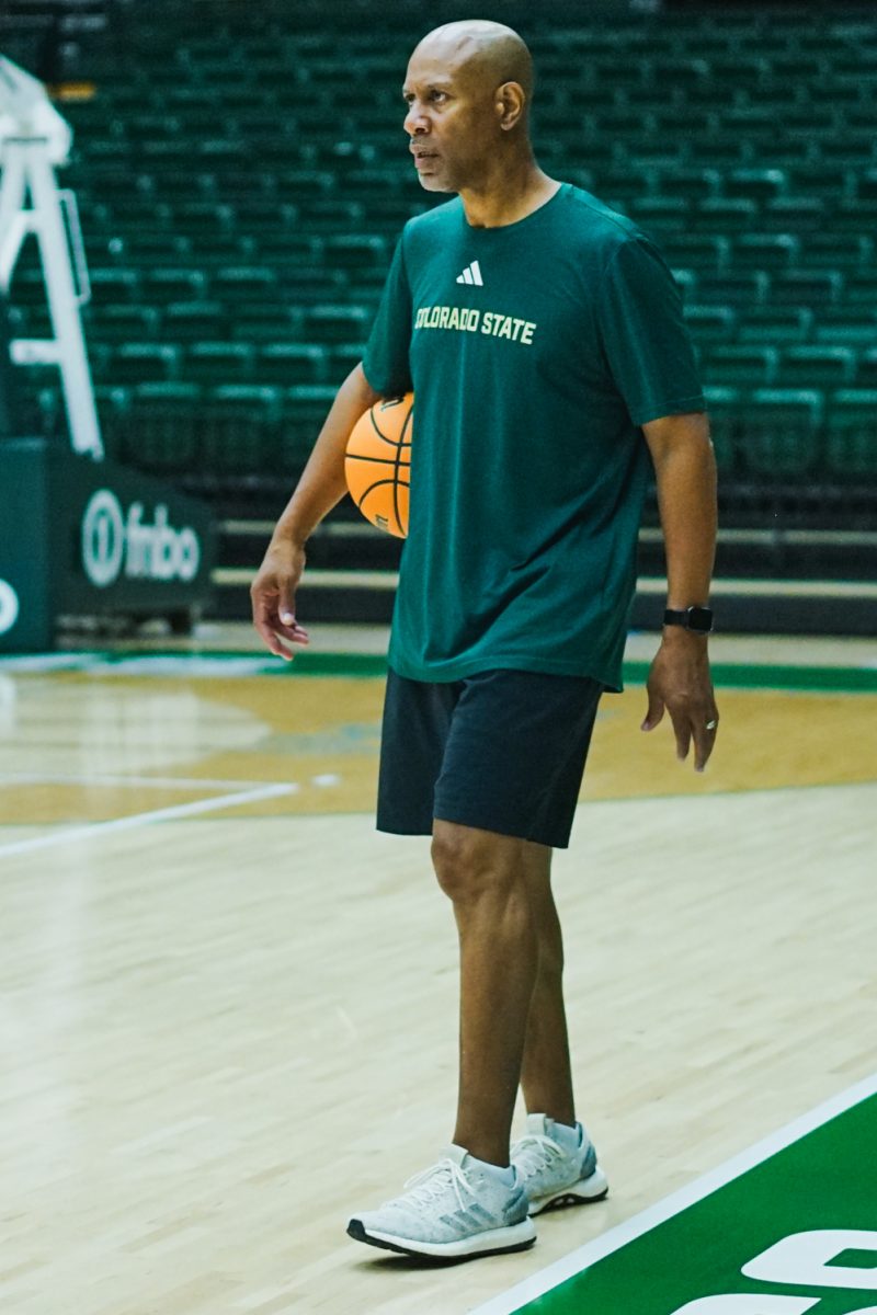 Rico Burkett, an assistant coach for the Colorado State University Women's Basketball team, carries a ball on the court as he watches his players run a drill during a practice session in Moby Arena Sept. 22.