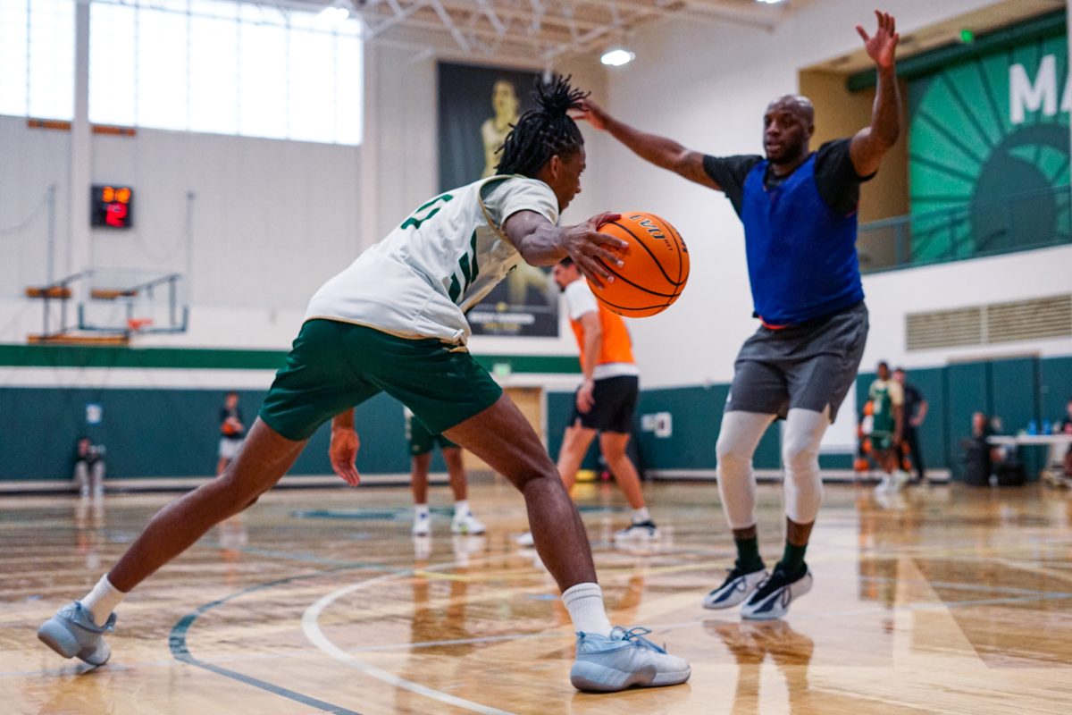 Carey Booth (0), a forward on the Colorado State University men's basketball team, dribbles the ball around a defender during a practice in CSU's indoor practice facility Sept. 24.