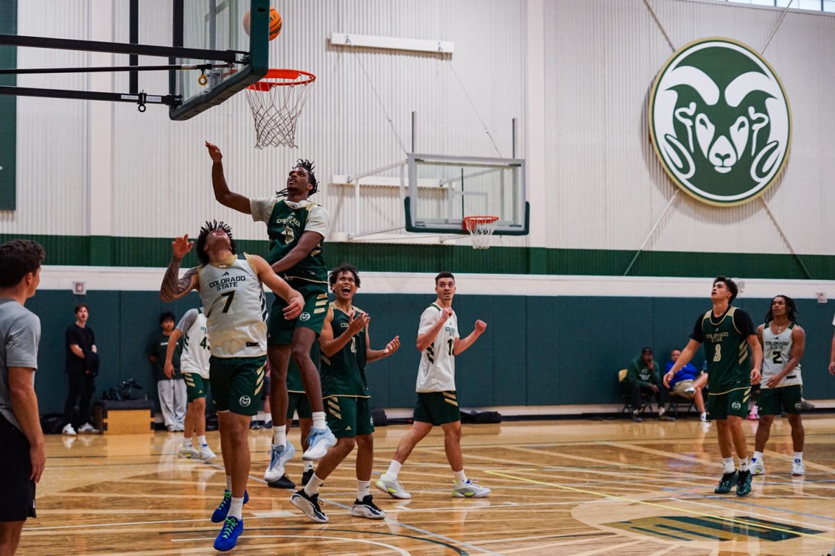 Jaden Ghoreishi (7) watches the ball after Carey Booth (0) completes a layup, and his teammates cheer during a practice scrimmage at Colorado State University's indoor practice facility.