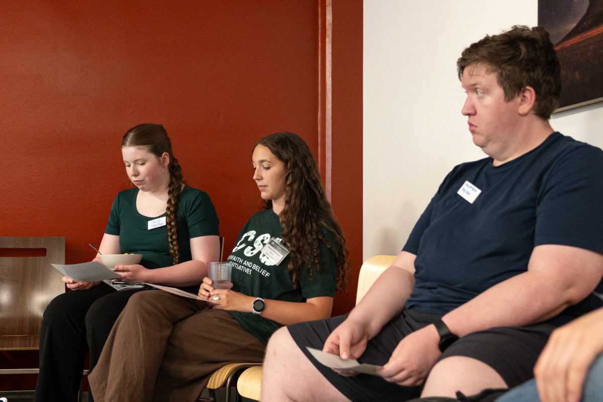 Tess Cooper, Sierra Brewster and Mattew Leman follow along to Laura Nelson's speech, the interim lead for the Multifaith & Belief Initiatives at the Foundry Sept. 3. 