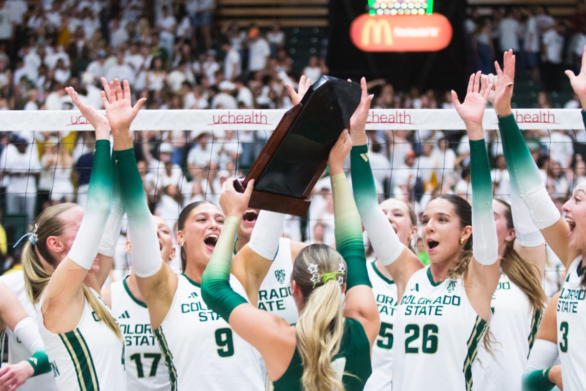 Colorado State University volleyball players cheer for their teammate Karsyn Fetzer (1), who raises the golden spike trophy after CSU's comeback victory against the University of Colorado, Boulder Sept. 18. 8,083 fans packed Moby arena for the Rams' white-out game, cheering CSU on to win three straight sets against CU.