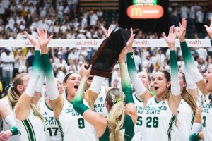 Colorado State University volleyball players cheer for their teammate Karsyn Fetzer (1), who raises the golden spike trophy after CSU's comeback victory against the University of Colorado, Boulder Sept. 18. 8,083 fans packed Moby arena for the Rams' white-out game, cheering CSU on to win three straight sets against CU.