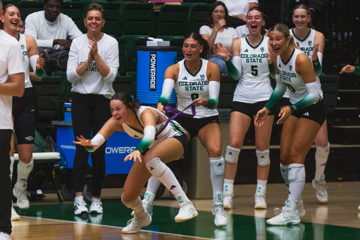 Silvie Graetzer (9), a middle blocker on the Colorado State University volleyball team, celebrates a point with her teammate during CSU's white-out game against the University of Colorado, Boulder. During this game, the Rams swept the Buffs 3-0 in front of a home crowd of 8,083 fans.