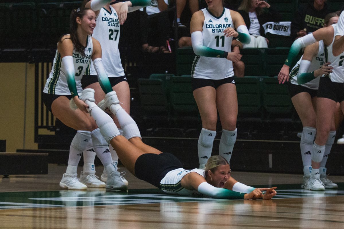 Brooke Holman (3), a junior on the Colorado State University volleyball team, carries her teammate by the legs to celebrate a point for the Rams during their rivalry game against the University of Colorado, Boulder Sept. 18. The Rams won this game, the second in a double header, 3-0 after a night one loss, and a sold-out home crowd watched as they lifted the golden spike after the game.