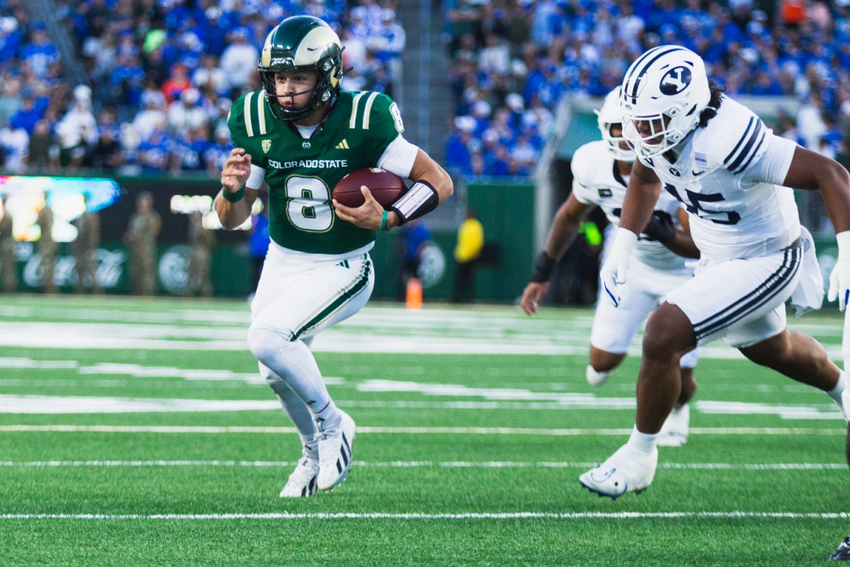 Colorado State University quarterback Hauss Hejny (8) runs with the ball under pressure from Brigham Young University cornerback Jayven Williams (15) during the first quarter of CSU's game against BYU Sept. 19. CSU lost the game 41-23.