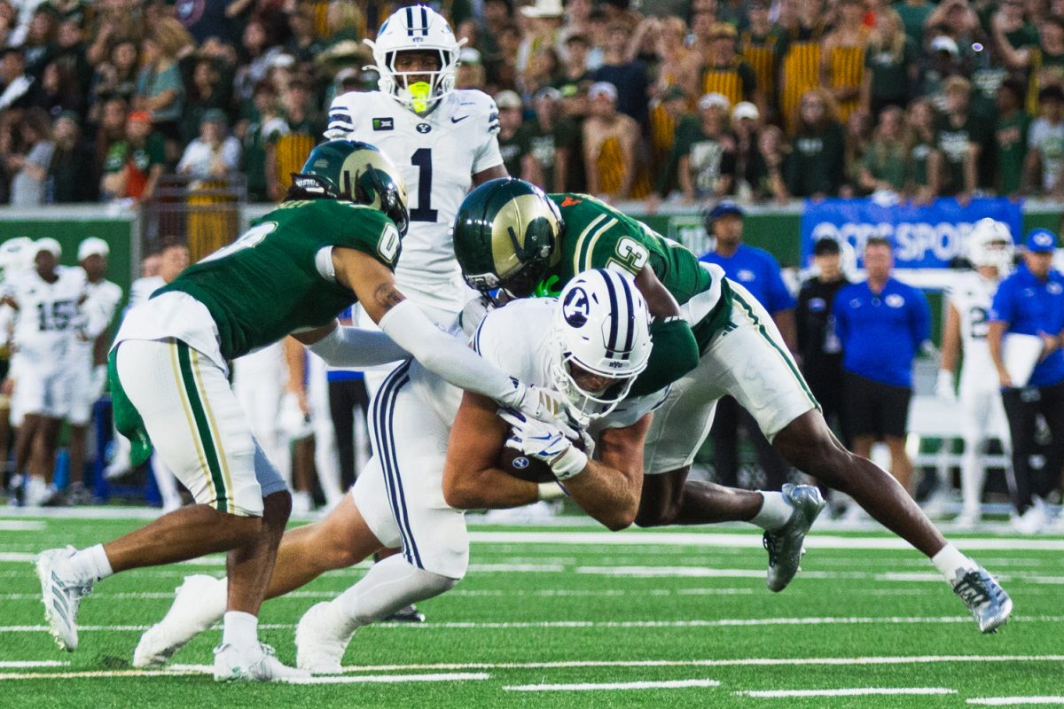 Caleb Presley (0) and Elijah Mc-Cantos (13), defensive players on the Colorado State University football team, tackle a Brigham Young University player during the first half of CSU's game against BYU Sept. 19. CSU lost the game 41-23.