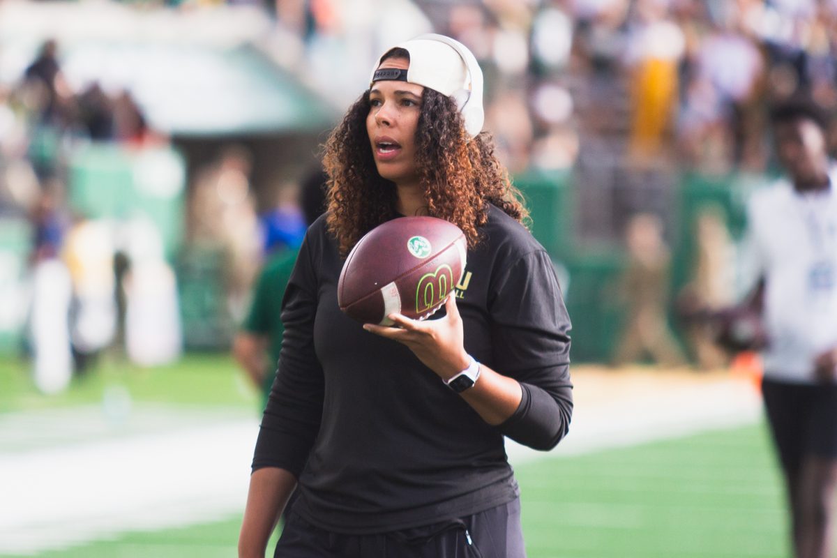 Mickey Grace, Pass Rush Specialist for the Colorado State University football team, carries a ball along the sidelines during warmups for CSU's football game against Brigham Young University Sept. 19.