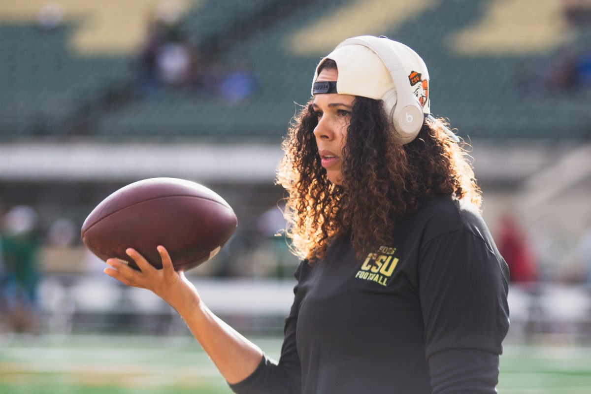 Mickey Grace, director of player development for the Colorado State University football team, carries a ball along the sidelines during warmups for CSU's football game against Brigham Young University Sept. 19.