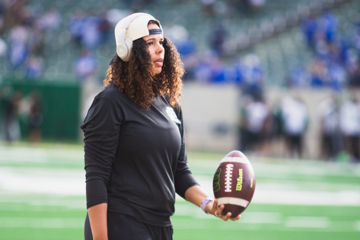 Mickey Grace, Pass Rush Specialist for the Colorado State University football team, carries a ball along the sidelines during warmups for CSU's football game against Brigham Young University Sept. 19. 