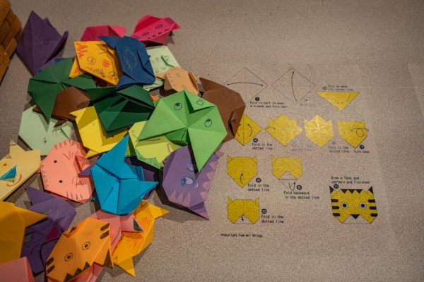 "Zhen’s Journey: Inspire" is displayed in the "Work and Wonder: Behind the Scenes at the Museum" exhibit inside The Global Village Museum of Arts and Cultures Sept. 11. The interactive piece teaches attendees how to create an origami cat.