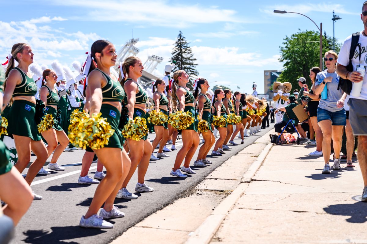 Colorado State University cheerleaders perform alongside the CSU color guard, Golden Poms and marching band at the tailgate before CSU football's game against the University of Wyoming Sept. 5. 