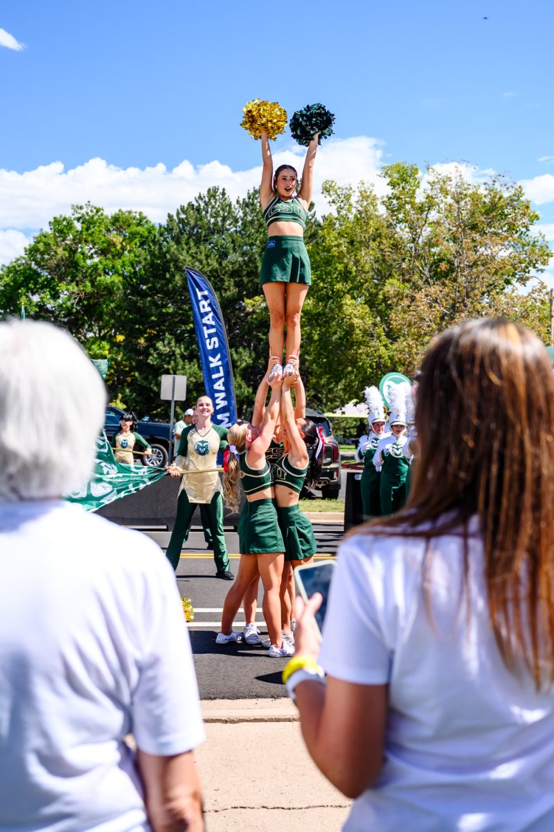 Colorado State University cheerleaders perform alongside the CSU color guard, Golden Poms and marching band at the tailgate before CSU football's game against the University of Wyoming Sept. 5. 