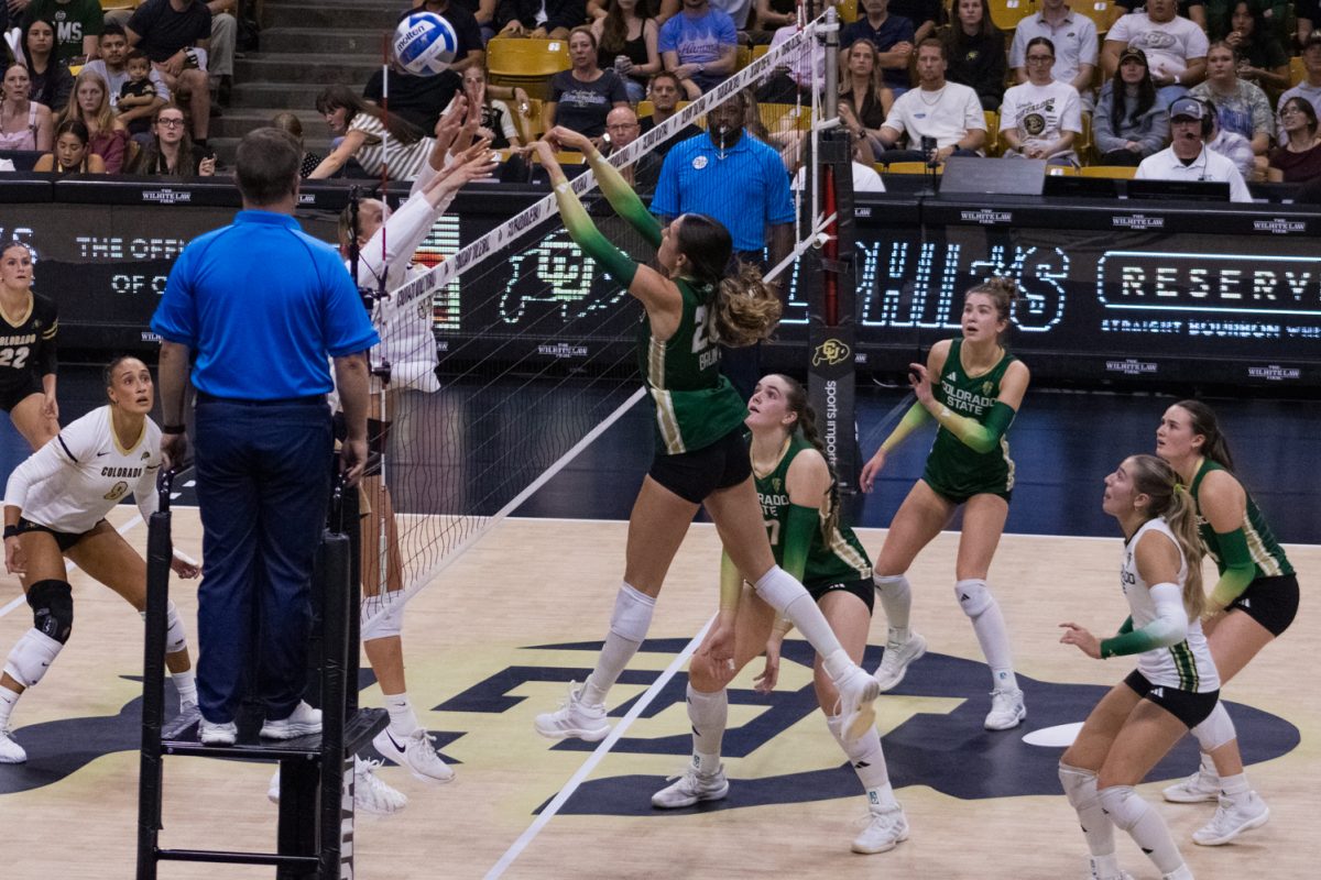 Colorado State University's Maria Brun (26) tips the ball over outstretched arms of University of Colorado, Boulder defense during their volleyball game at CU Events Center Sept. 17.