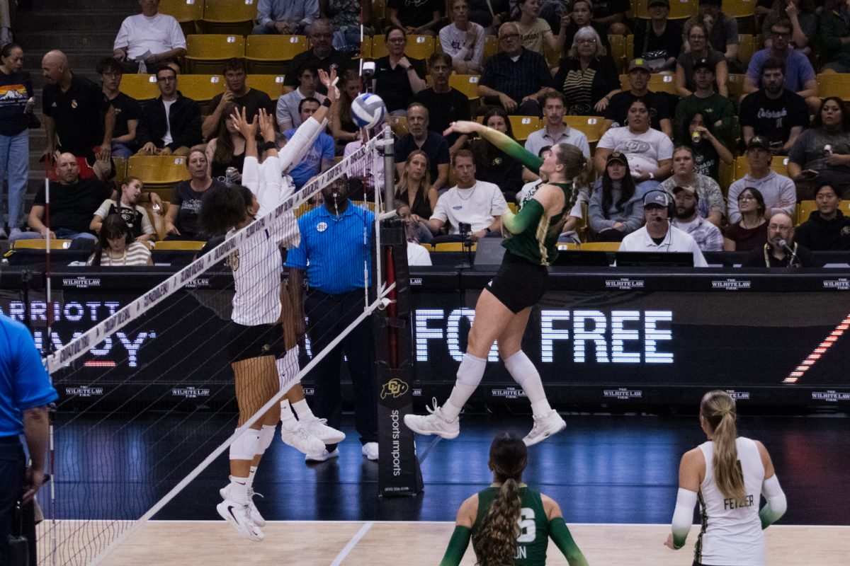 Colorado State University volleyball middle blocker Eve Wilson (27) follows through after spiking the ball over the net during their game against the University of Colorado, Boulder at the CU Events Center Sept. 17. Wilson led the rams in blocks against the Buffaloes, completing seven over the nights' four sets. 