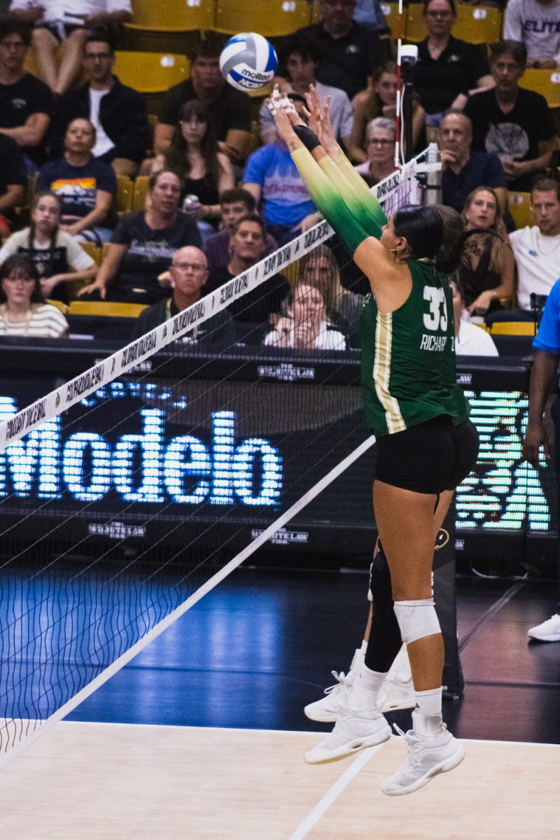 Kekua Richards (33) jumps up with a teammate to block an attack from the University of Colorado, Boulder volleyball team during their away match at the CU Events Center Sept. 17. After a hard-fought four sets, the Rams lost this match 3-1.
