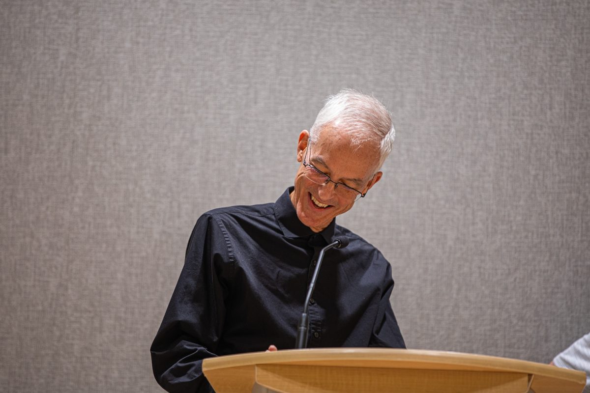 Poet and University of Wyoming Professor H. L. Hix smiles at the podium during the Creative Writing Reading Series Sept. 10.