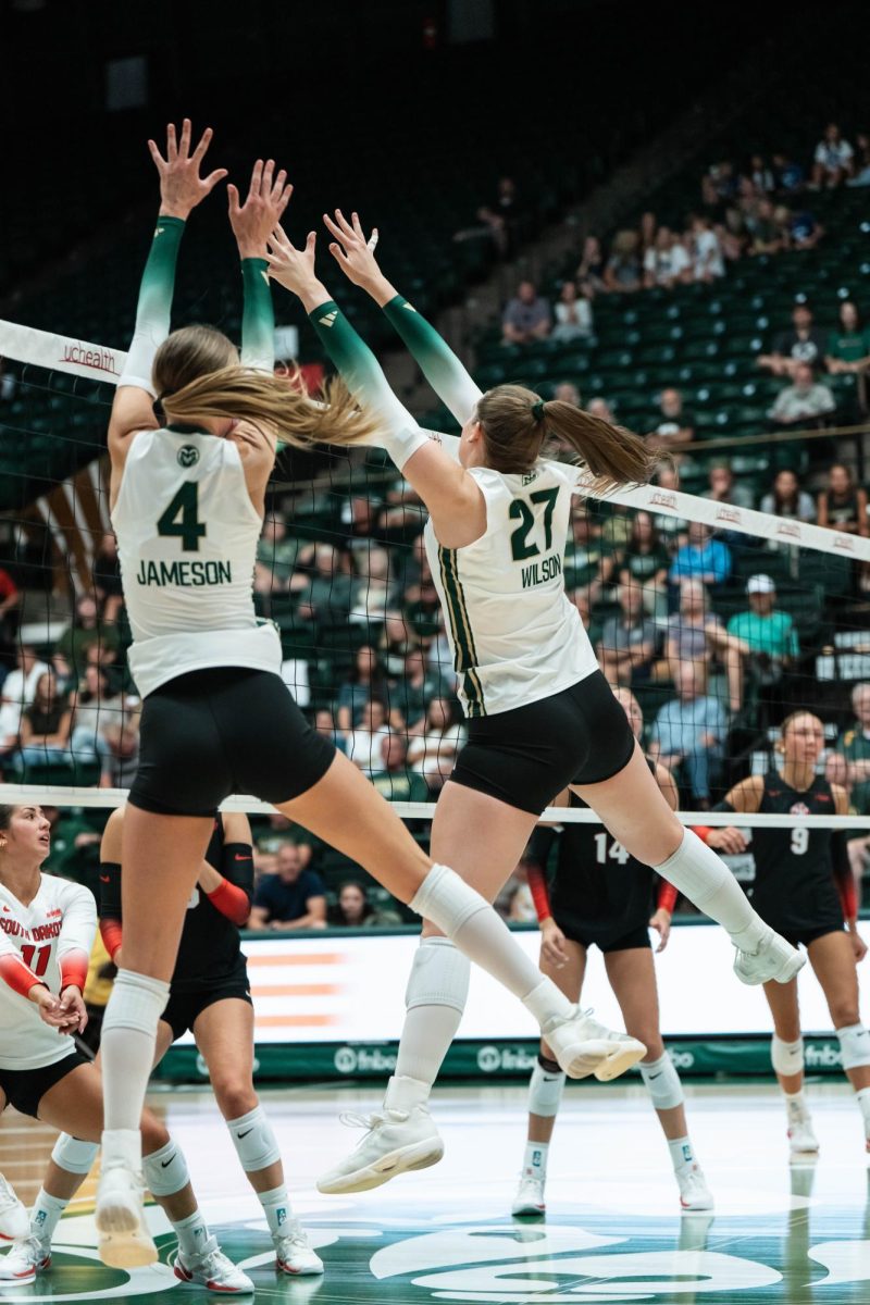 Halle Jameson (4) and Eve Wilson (27) reach to block the ball Sept. 10. Colorado State University defeated the University of South Dakota 3-0.