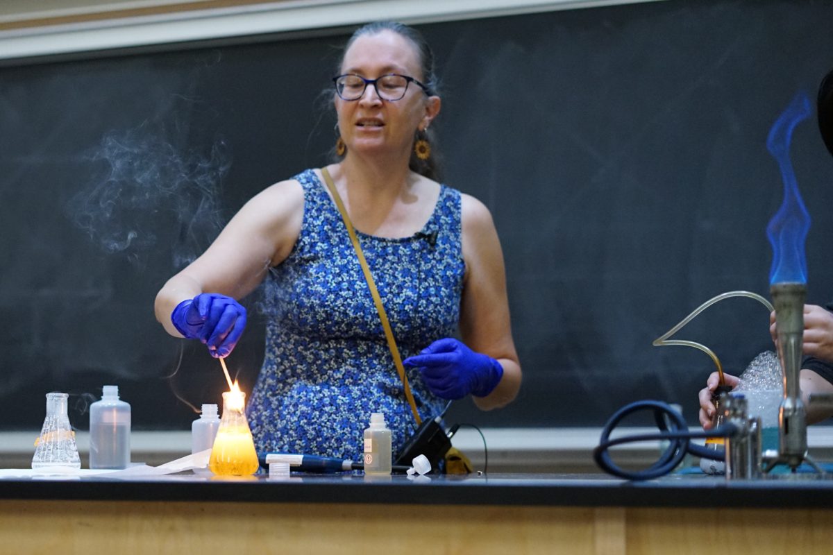 Ruth Tucker, a master instructor at Colorado State University, dips a burning wooden skewer into a beaker during an in-class demonstration in the Chemistry building Oct. 1. Her students watched as the oxygen, produced by a chemical reaction, re-lit the previously extinguished flame..