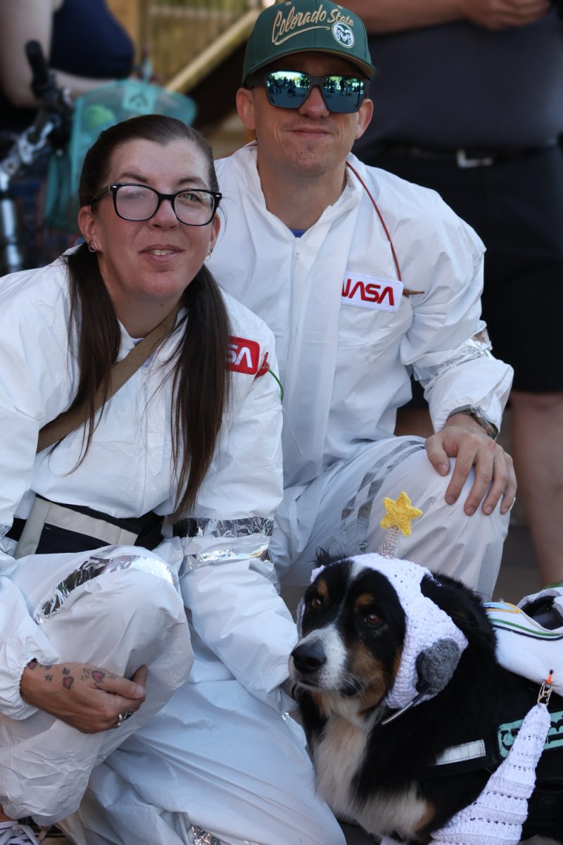 Gary the Borgi (corgi and border collie mix) with his owners Sarah and Jared, Civic Center Park, Oct. 3rd. The trio are dressed and ready for a high-stakes space adventure, or attending the 2026 Tour de Corgi; Sploots in Space.
