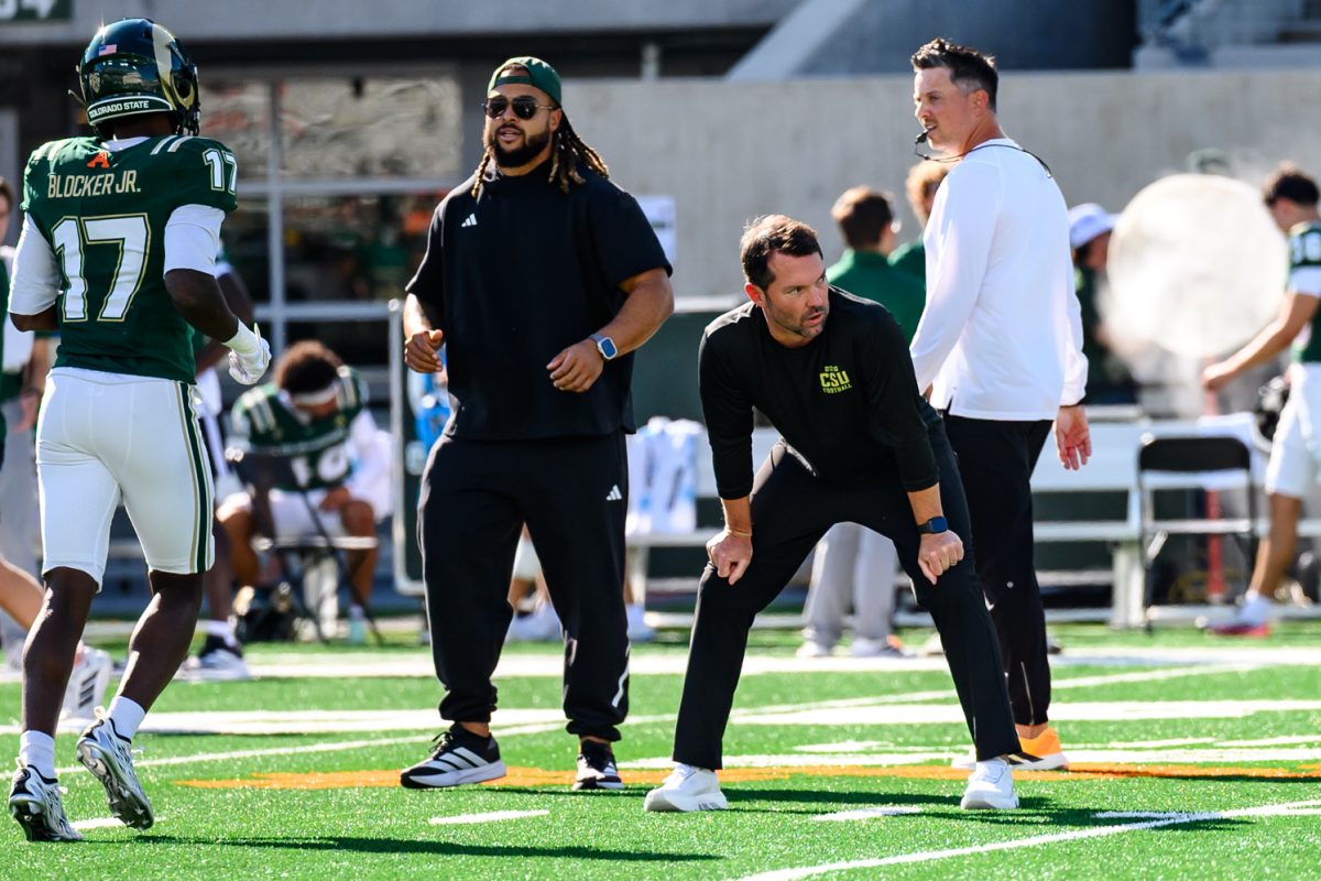 Former Colorado State University football defensive coordinator Tyson Summers works with players during warm ups for CSU's Homecoming game against Oregon State University Oct. 3.