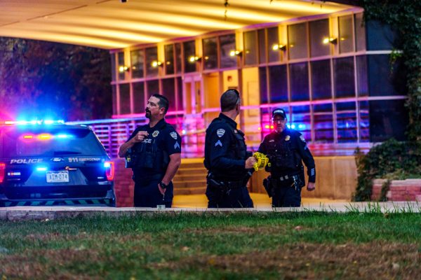 Fort Collins Police Services officers prepare to expand the barrier tape around the Colorado State University Microbiology and Chemistry Buildings after an officer-involved shooting Oct. 12.