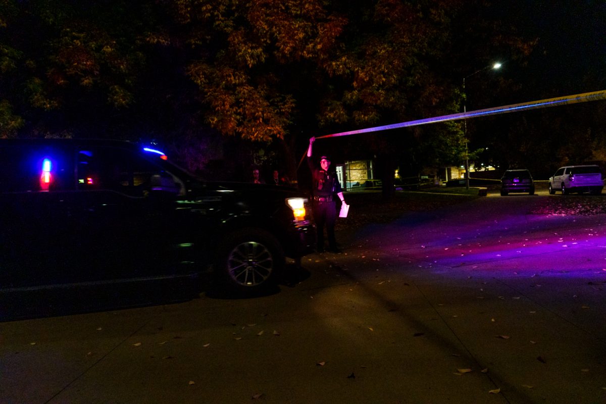 A Fort Collins Police Services officer lifts the barricade tape around Colorado State University's Microbiology Building to let in a police vehicle after an officer-involved shooting Oct. 12. 