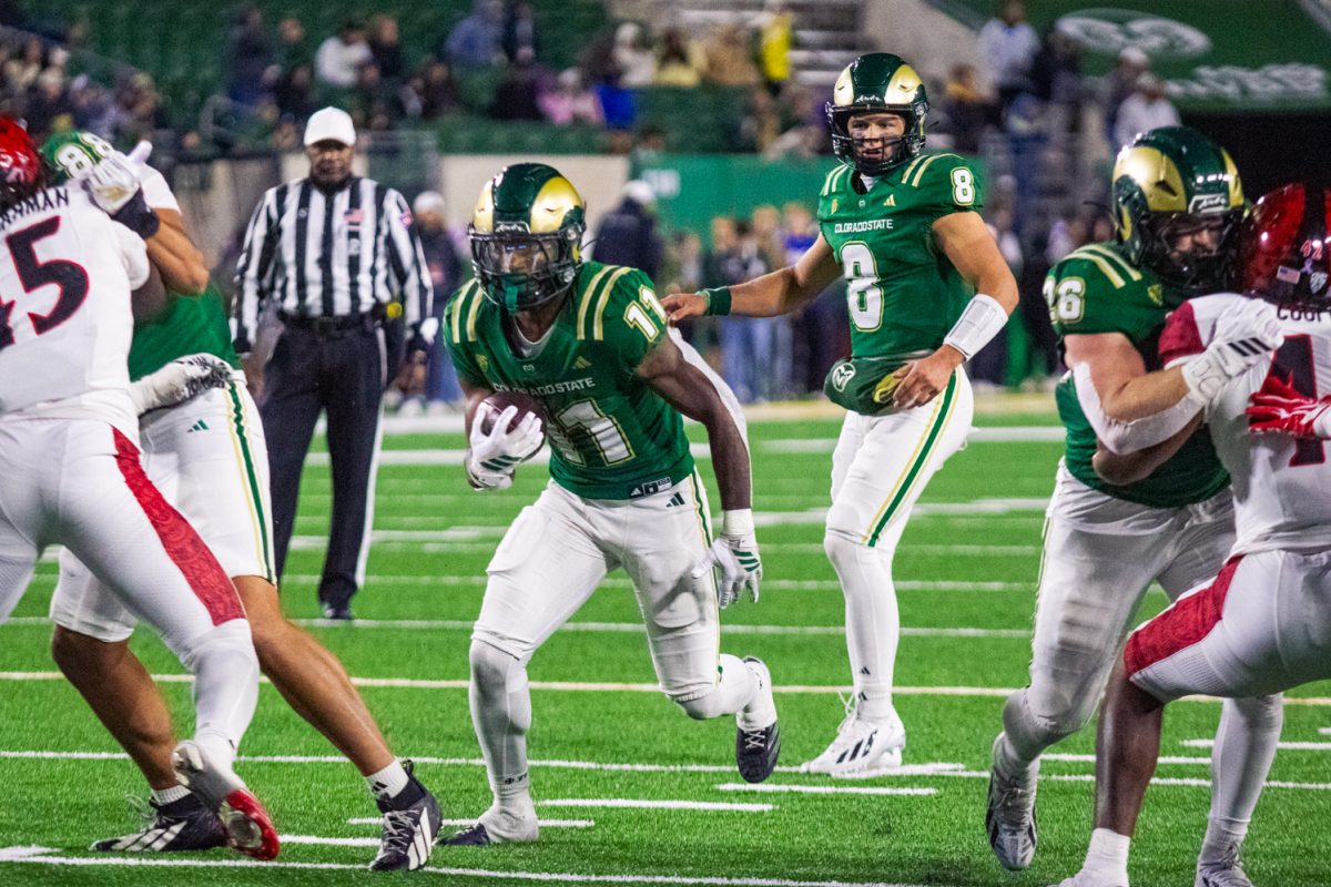 Running back Durell Robinson (11) runs the ball through the line of scrimmage as his teammates tackle the San Diego State University defense during a football game in Canvas Stadium Oct. 24. Robinson had the most rushing attempts of any CSU rusher with 19 attempts totaling 86 yards.