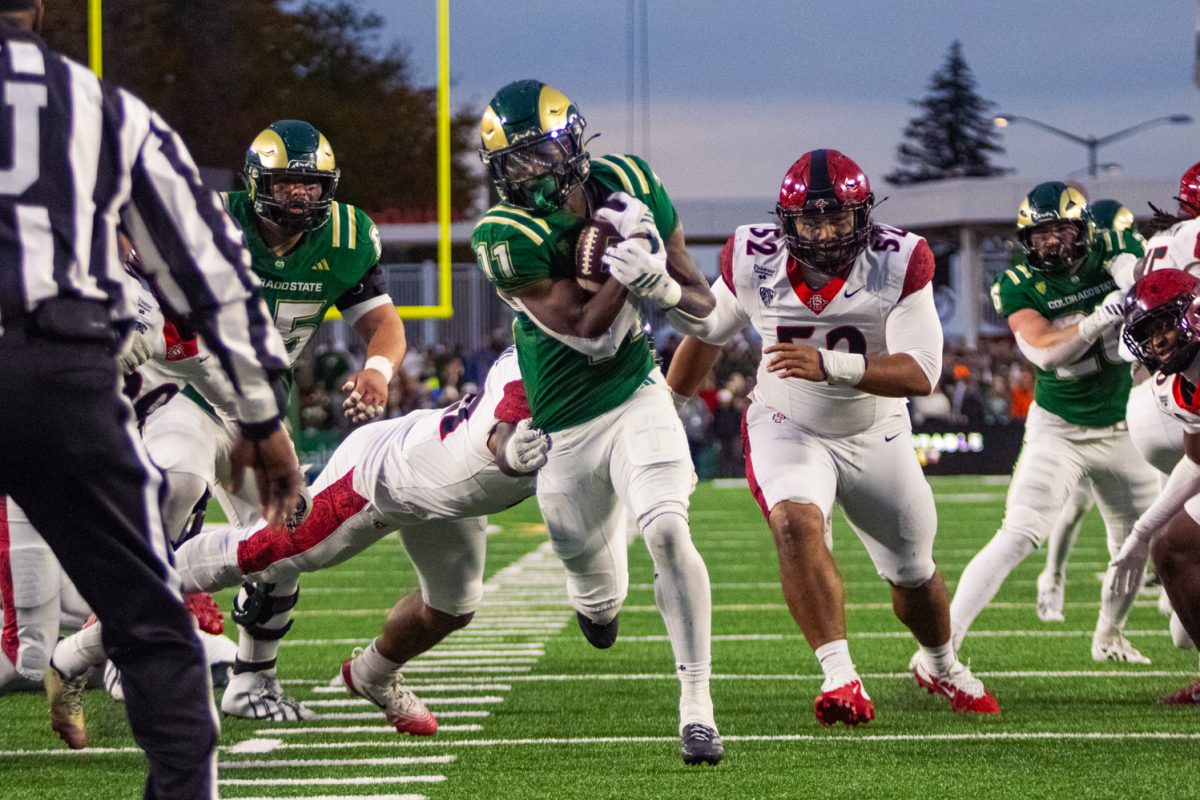 Colorado State University running back Durell Robinson (11) pushes through the San Diego State University defense to score a touchdown for the Rams during their game in Canvas Stadium Oct. 24. This was one of two touchdowns in the first half of the game for Robinson.