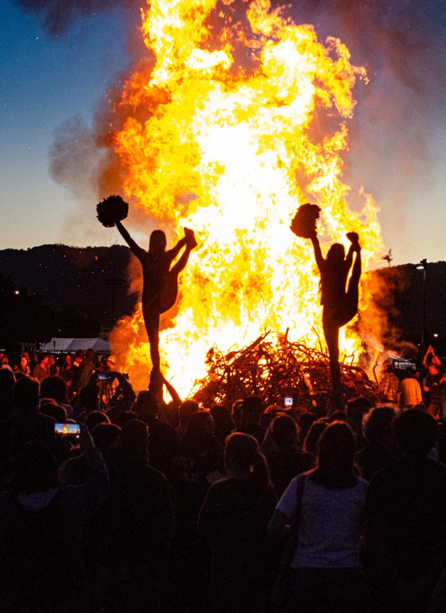 Colorado State University cheerleaders perform a group stunt for a crowd of students and families in front of the Homecoming Bonfire on the West Lawn of the Lory Student Center Oct. 2. 